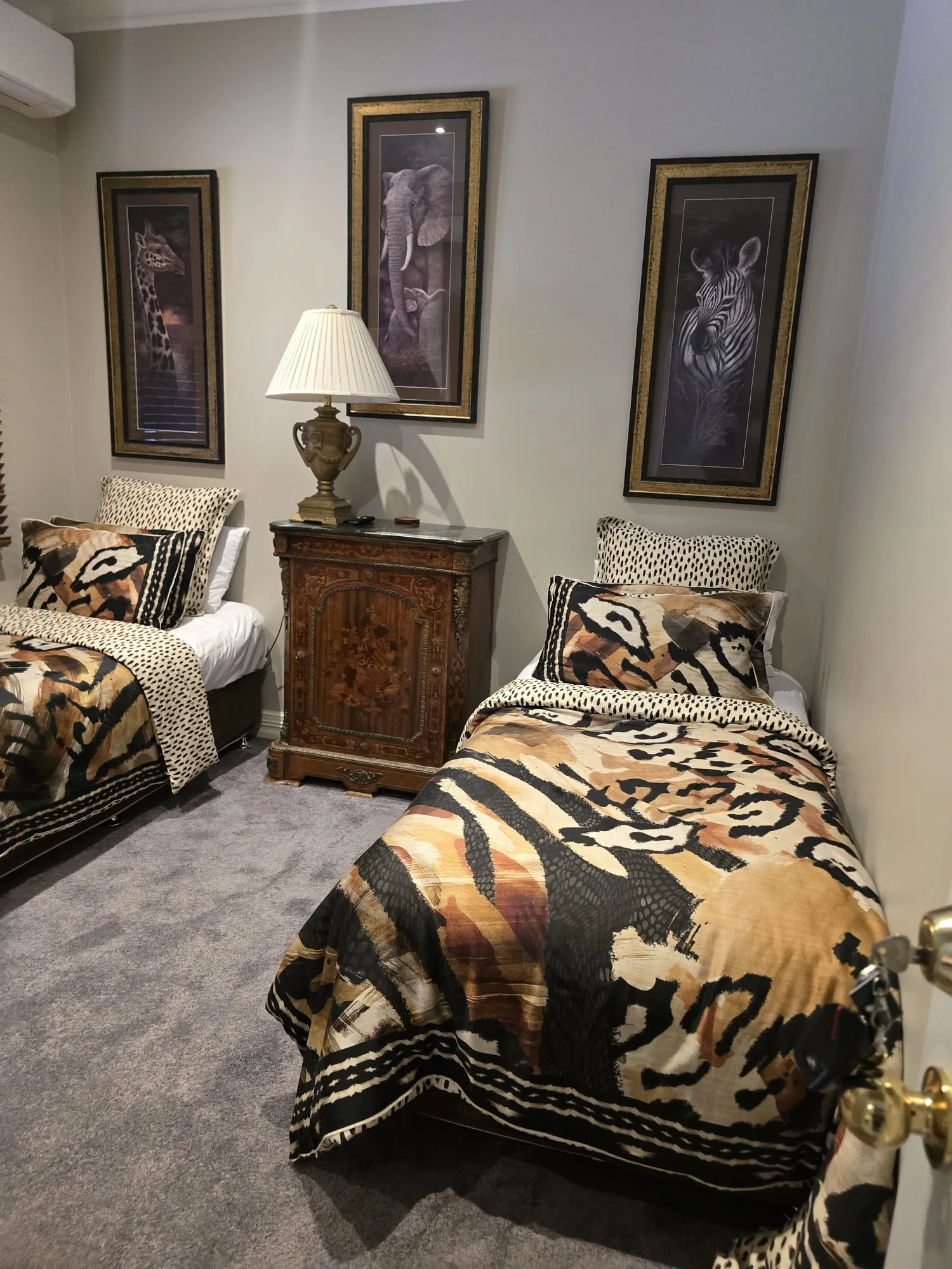 Emmylou twin room with two single beds in animal-print quilts and framed wildlife art
