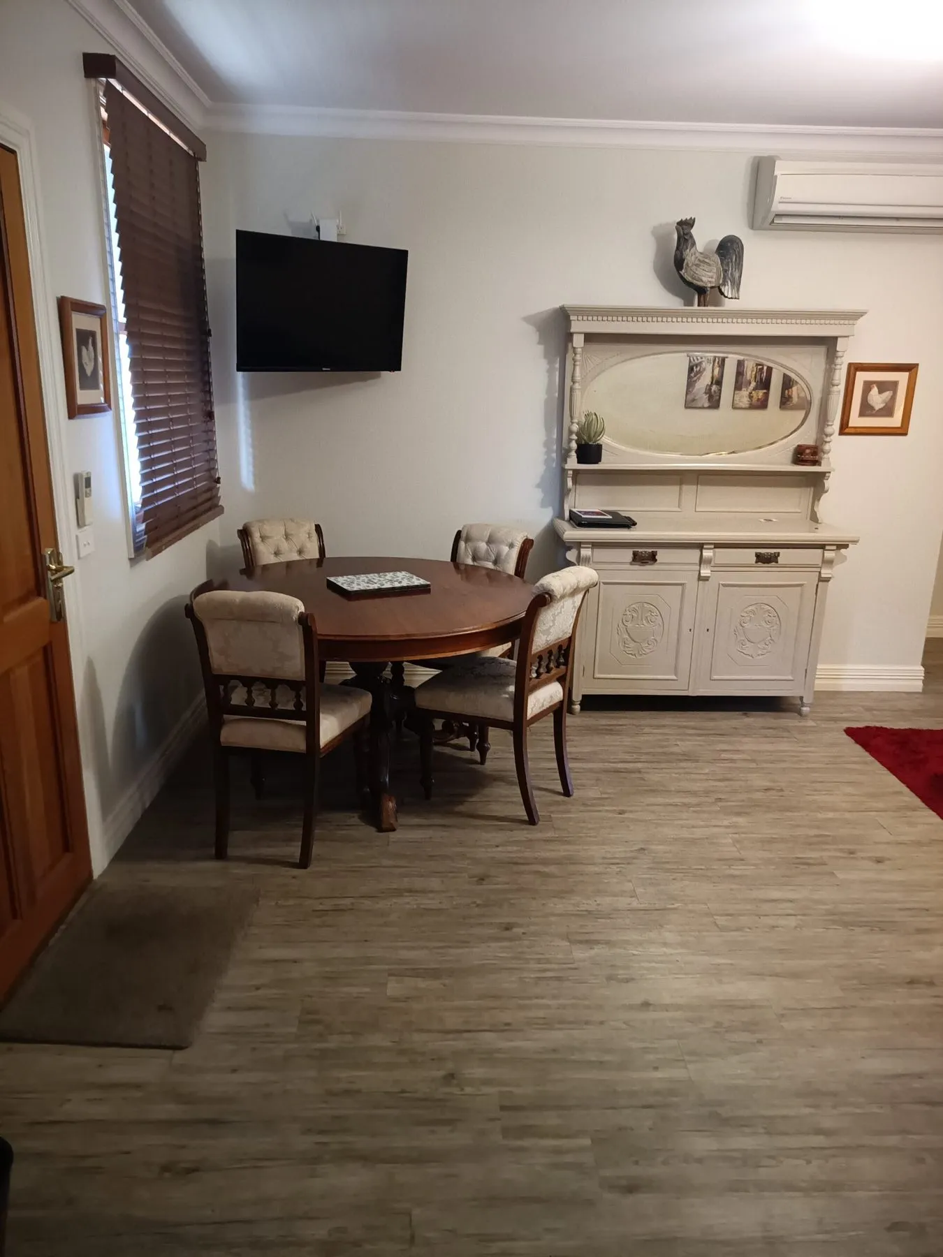 Round antique dining table and a painted dresser in the Etona Suite