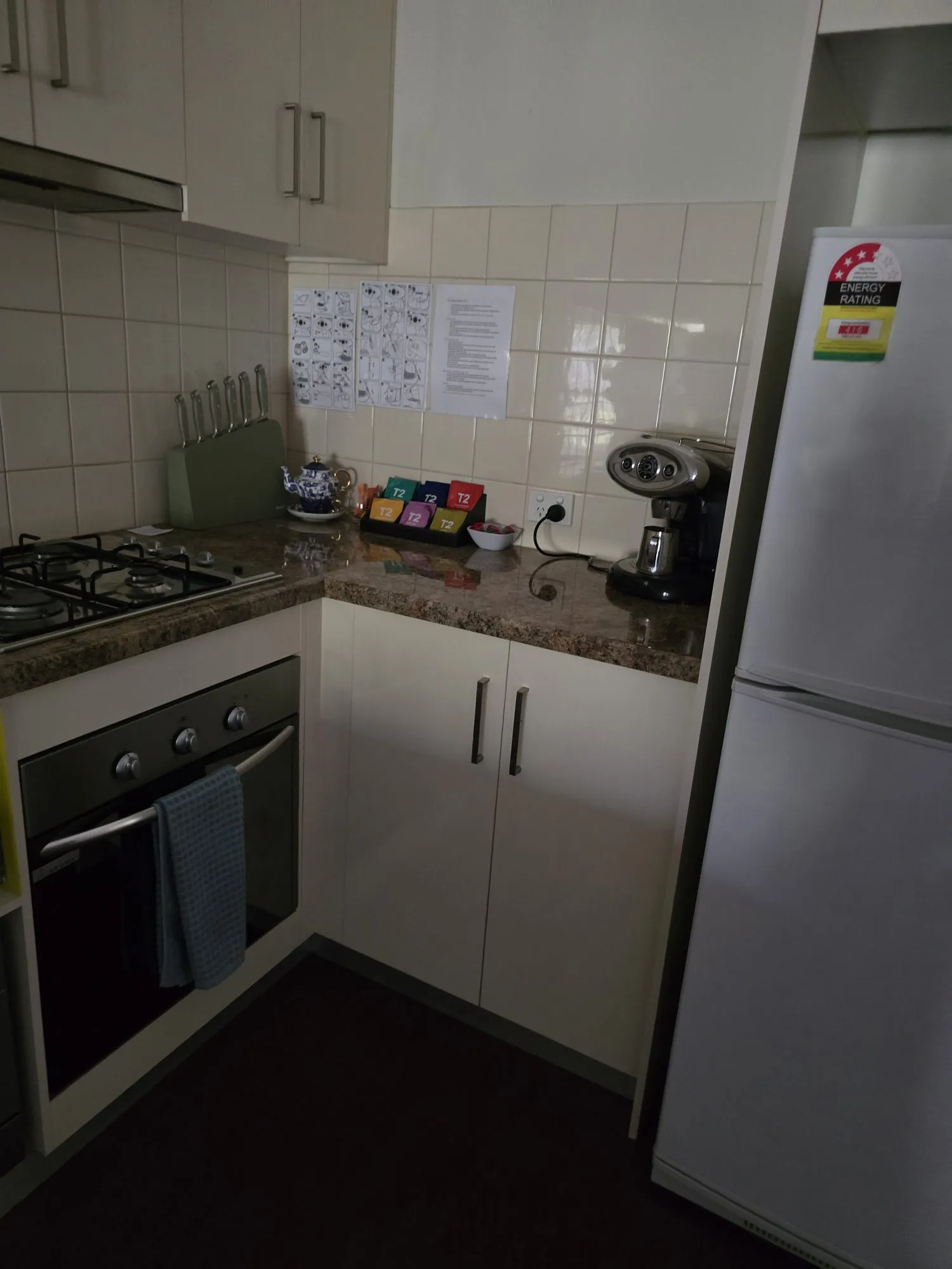 Kitchen with gas cooktop, oven, coffee machine and a full-size fridge