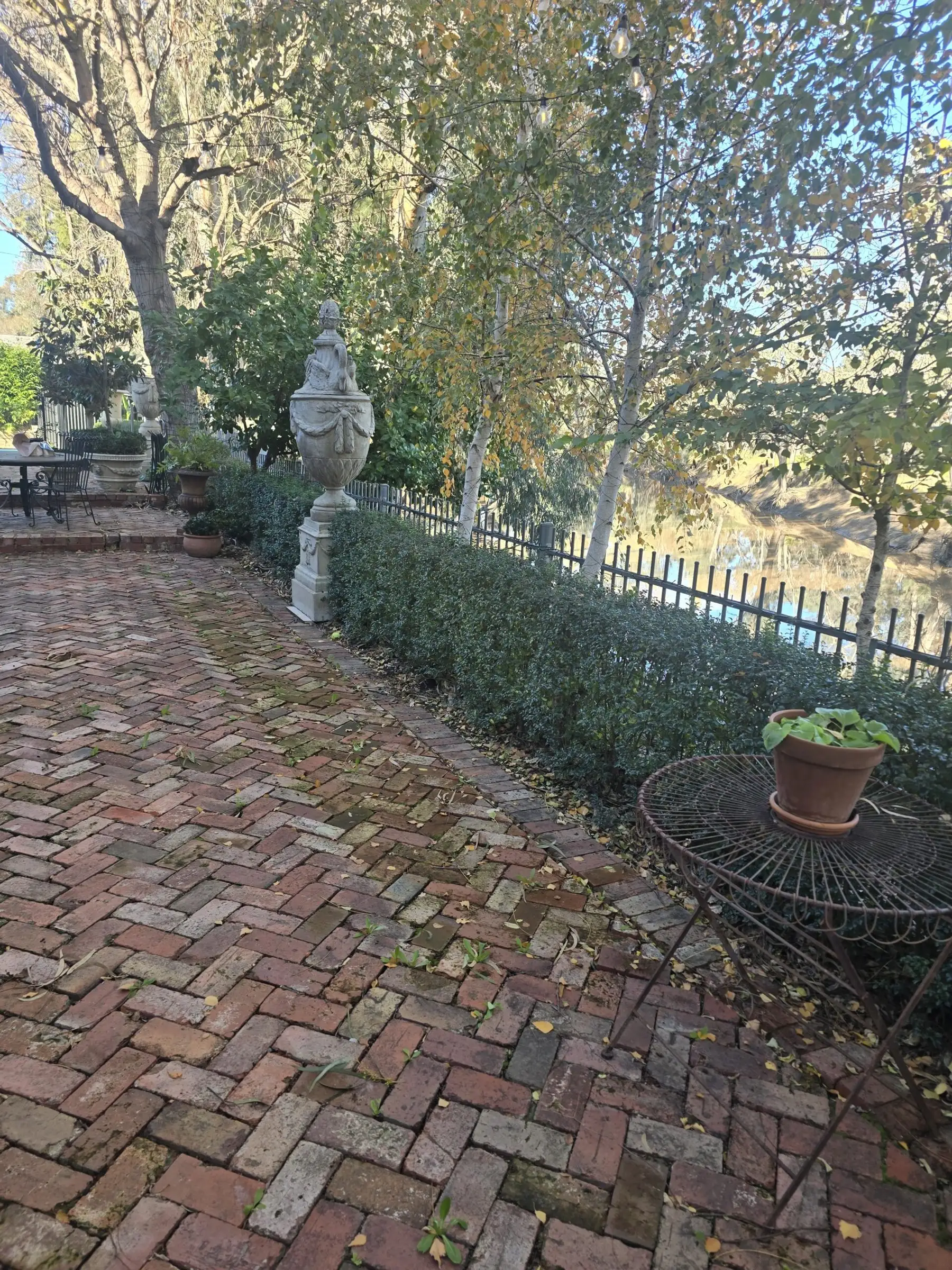 Herringbone brick path through the courtyard garden to the river fence
